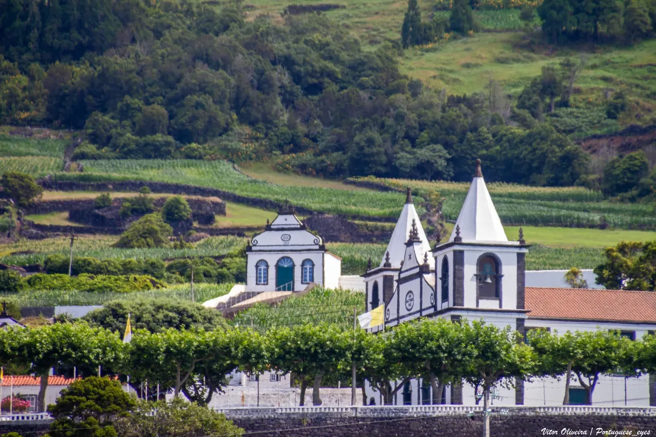 Das Heiligtum des Senhor Bom Jesus Milagroso mit seinen weißen Türmen in São Mateus, Pico, vor grünen Feldern