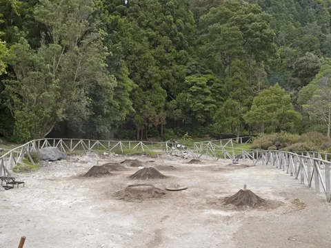 The fenced fumarolic field by Lagoa das Furnas, with earth mounds over the cozido cooking holes